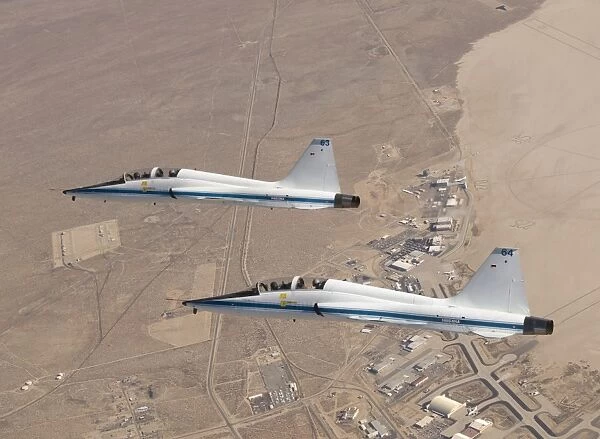 Two T-38A mission support aircraft fly in tight formation
