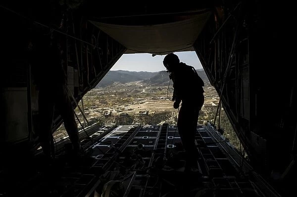 U. S. Air Force Airman pushes out pallets from a C-130H Hercules