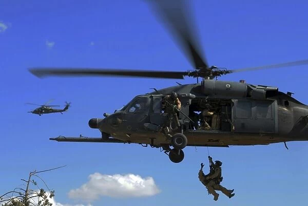 U. S. Air Force Pararescuemen are hoisted into an HH-60 Pavehawk helicopter