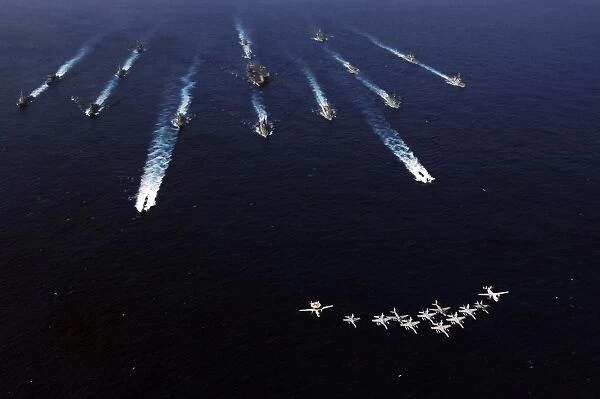 U. S. Navy aircraft fly over a formation of U. S. and Japanese ships