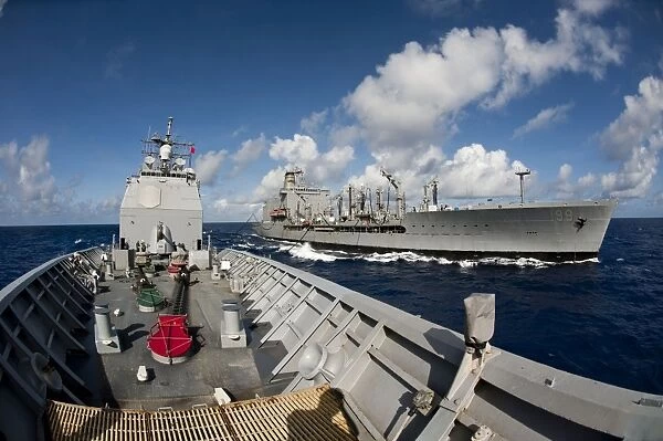 USS Cowpens transits alongside USNS Tippecanoe
