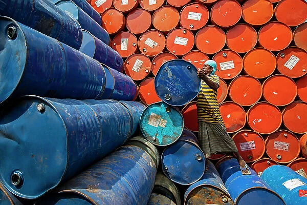 Worker sorting colorful oil drums