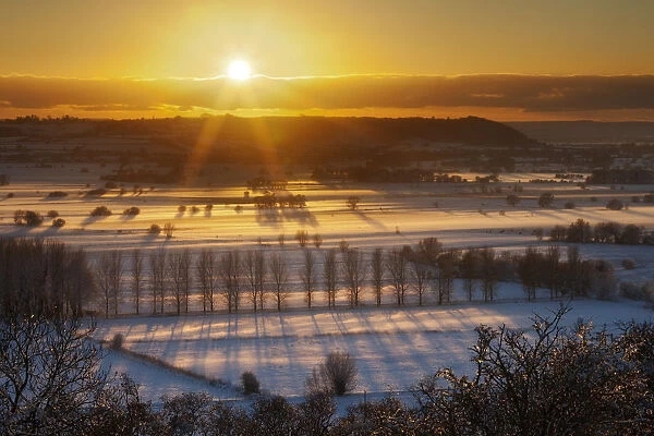 Winter sunset over the Somerset Levels from Walton Hill on a misty evening with snow on the ground