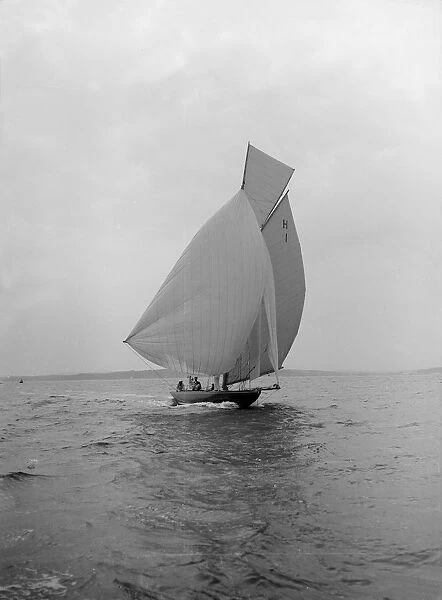 The 8 Metre class Antwerpia IV sailing under spinnaker, 1912. Creator: Kirk & Sons of Cowes