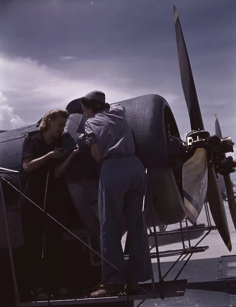 Bowen and Olsen, a riveter and her supervisor, in the... Naval Air Base, Corpus Christi, Texas, 1942. Creator: Howard Hollem