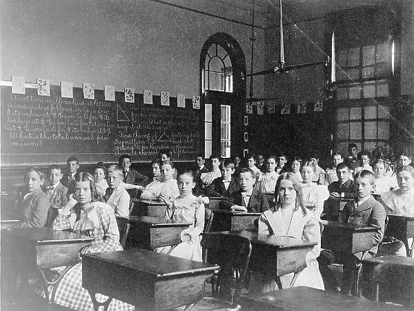 Girls and boys seated at desks in Washington, D.C. classroom, (1899?). Creator: Frances Benjamin Johnston