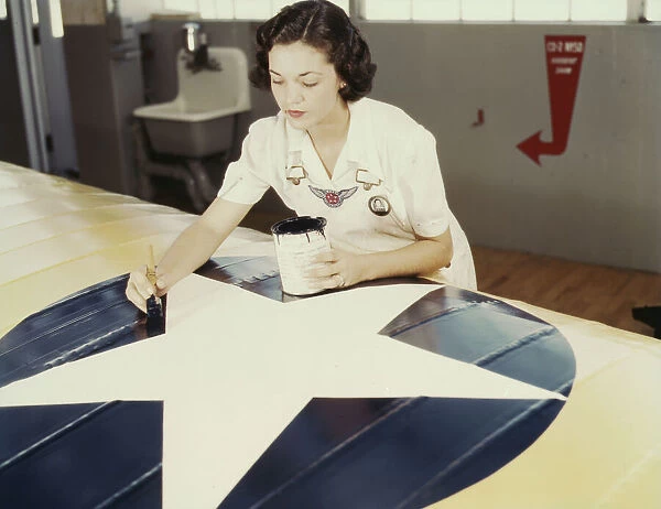 Painting the American insignia on airplane wings is a job that Mrs... Corpus Christi, Texas, 1942. Creator: Howard Hollem