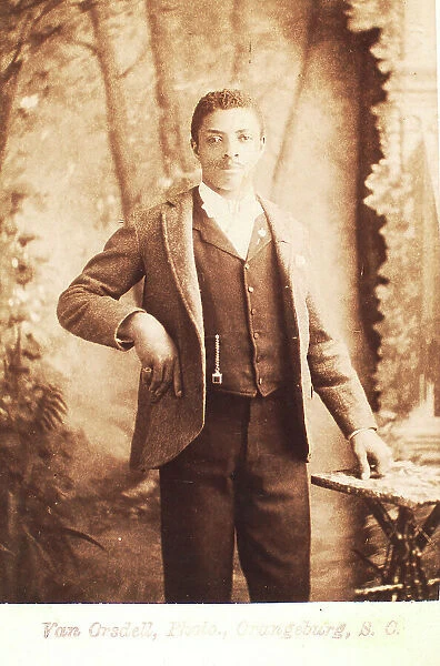 Studio portrait of man, hand on waist, (1880-1940?). Creator: Van Orsdell