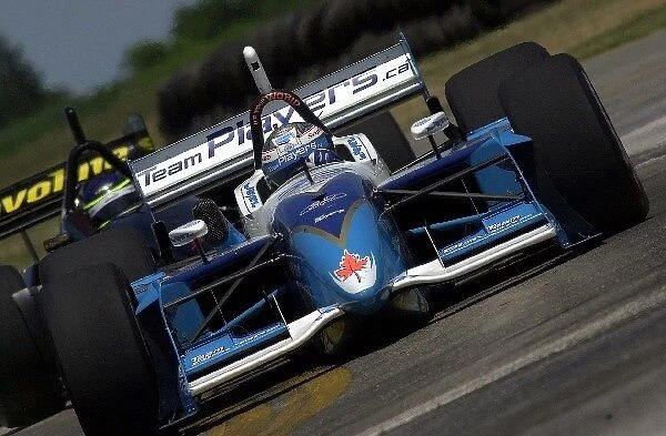 Alex Tagliani, (CAN), Ford-Cosworth  /  Reynard, leads Cristiano da Matta through turn eight on his way to twelth fastest in first round qualifying at the Marconi Grand Prix of Cleveland. Burke Lakefront Airport, Cleveland, Ohio. 14
