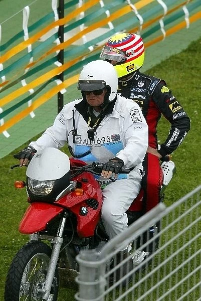 Formula One World Championship: Alex Yoong KL Minardi has a lift back to the pits on a motorbike after stopping out on the track