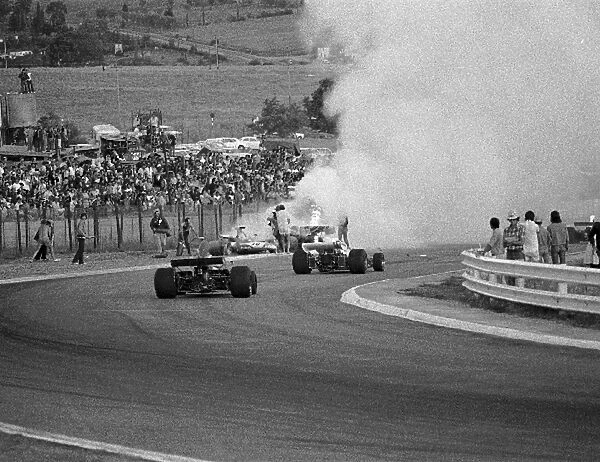 Formula One World Championship: Cars stream past the fiery accident involving Mike Hailwood, Clay Regazzoni and Jacky Ickx on lap 3