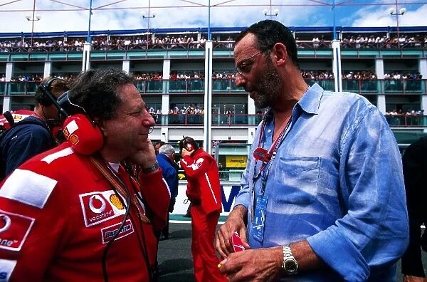 Formula One World Championship: Jean Todt Ferrari Sporting Director talks with actor Jean Reno on the grid before the start of the race