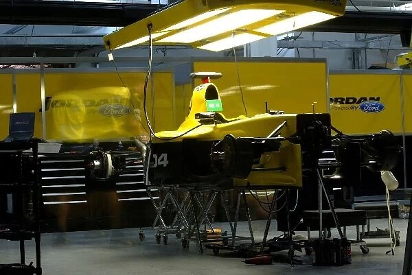 Formula One World Championship: Jordan mechanics work on the cars in the garage into the night