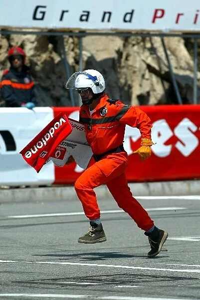 Formula One World Championship: A marshal retrieves the nose cone of Rubens Barrichello after his collision with Kimi Raikonen