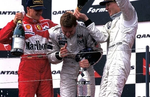 Formula One World Championship: The podium finishers Michael Schumacher Ferrari 2nd, David Coulthard McLaren 1st, Mika Hakkinen McLaren 3rd