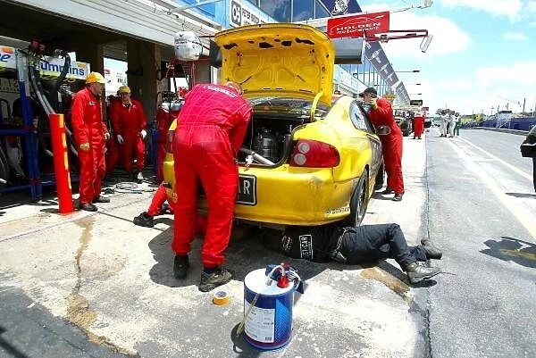 f2371. Mechanics work on the yellow Monaro, which lost the lead to the