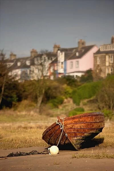 Alnmouth, Northumberland, England; An Abandoned, Rusted Boat Sitting On Land With Houses In The Background