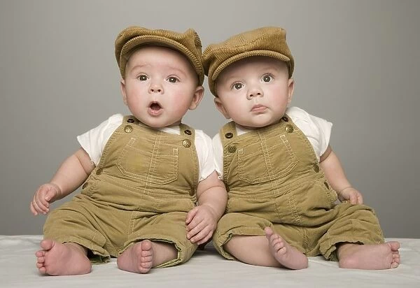 Two Babies In Matching Hat And Overalls