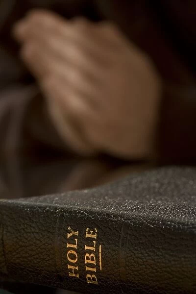 Bible With Praying Hands In Background