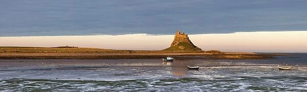 Boats In The Water And A Castle On The Tidal Island Also Known As Holy Island; Lindisfarne, Northumberland, England