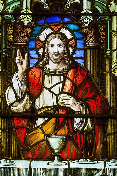 Close Up Of Stain Glass Window With Jesus Christ At A Table With Chalice And Holding Bread; Calgary, Alberta, Canada