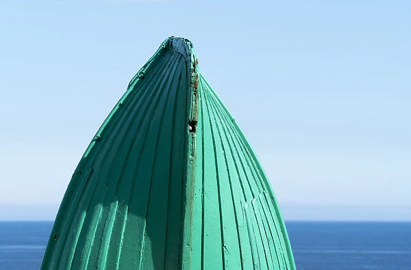 Close-Up Of The Bottom Of The Bow Of A Wooden Boat Painted Green And The Tranquil Water And Blue Sky In The Background; South Shields, Tyne And Wear, England