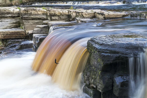 Coloured Waterfall Flowing Over A Cliff; Richmond, North Yorkshire, England