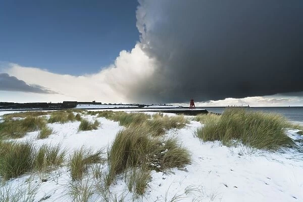 Dark Clouds And Blue Sky Over A Red Lighthouse Along The Coast In The Winter; South Shields, Tyne And Wear, England