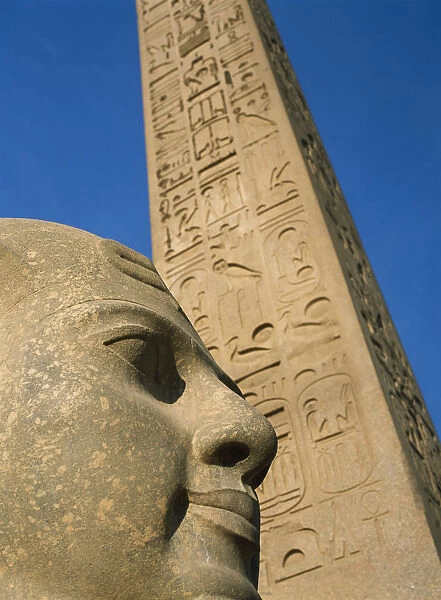 Egypt, Detail of head of pharaoh in front of obelisk at entrance to Luxor Temple; Luxor