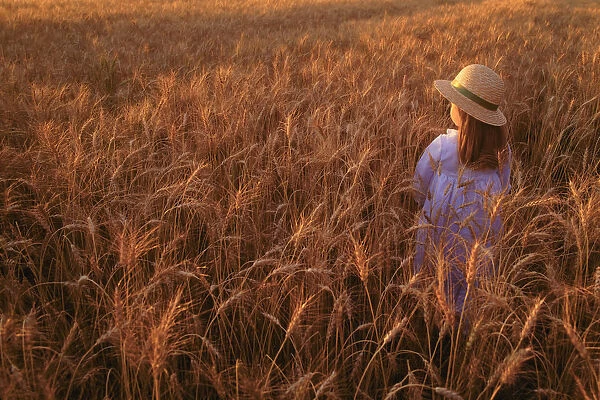 Girl with hat in field