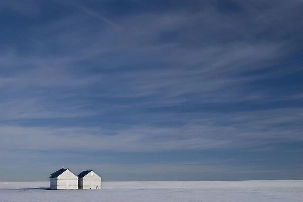Hussar, Alberta, Canada; Two Small Farm Buildings In Flat Winter Landscape