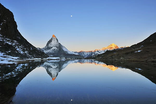 Matterhorn reflected in Lake Riffelsee at Sunrise with Moon, Zermatt, Alps, Valais, Switzerland