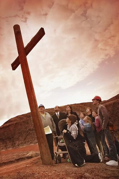 A Small Crowd Gathered At A Wooden Cross