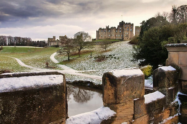 Snow On The Hills And Bridge With Alnwick Castle In The Background; Alnwick Northumberland England