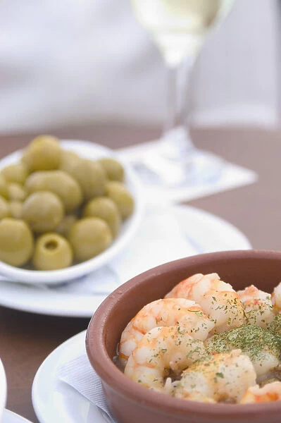 Spain, Tapas (olives and prawns) with glass of wine; Barcelona