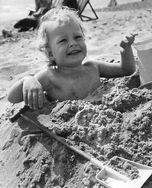 3 year old Bradley Hook up to his arm-pits in the sand at Bournemouth. April 1971 P023604