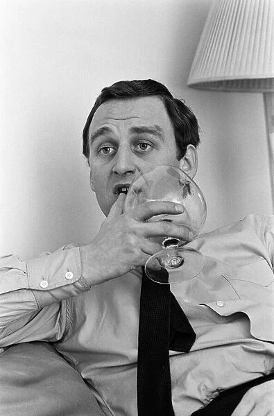 Actor John Thaw relaxing at home in London with a brandy. 30th March 1966
