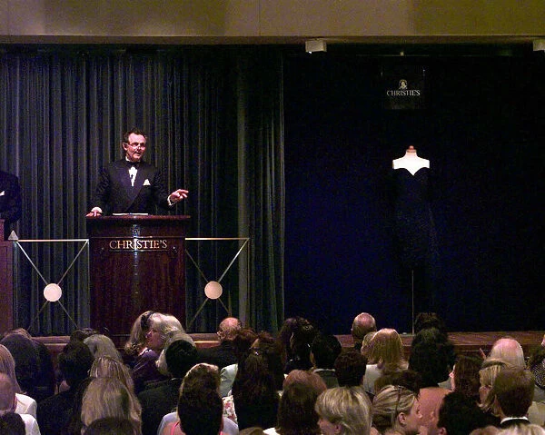 Auctioneer Lord Hindlip taking bids on Princess Dianas dcocktail dress in black silk