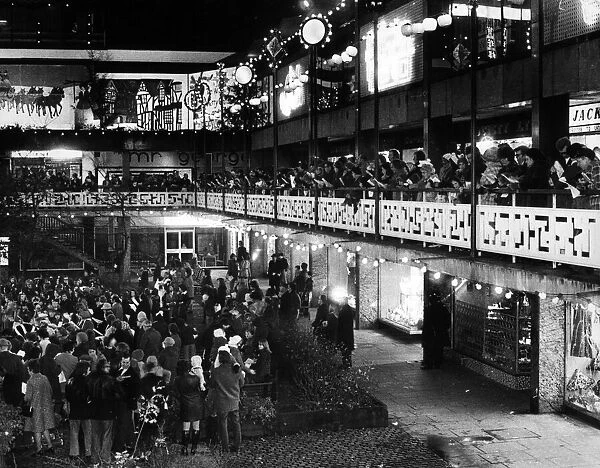 The blaze of lights from shops adds to the sparkle of Christmas lights as families gather