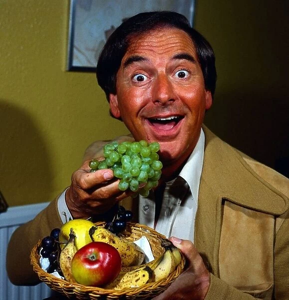 Bob Monkhouse holding basket of fruit August 1981
