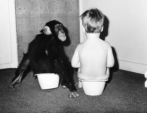 A boy and a monkey doing their business togehter. 1970