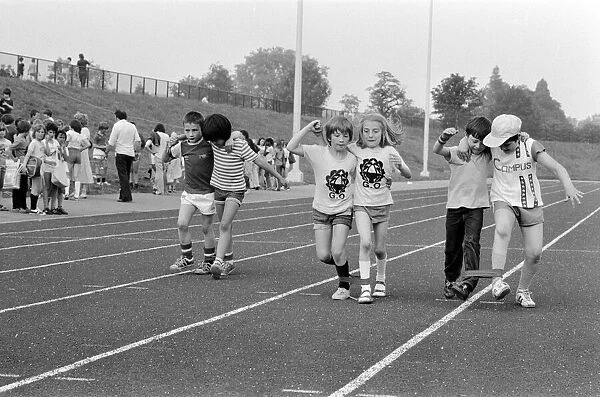 Boys and girls tied together as they take part in the Three Legged race at their school
