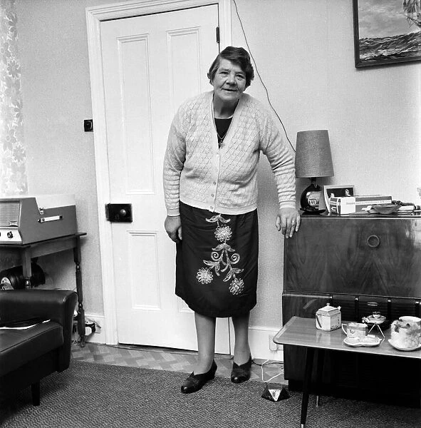 British family feature: A grandmother standing in her living room November 1969