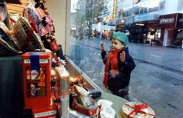 Christmas - A young child peers at the Christmas decorations