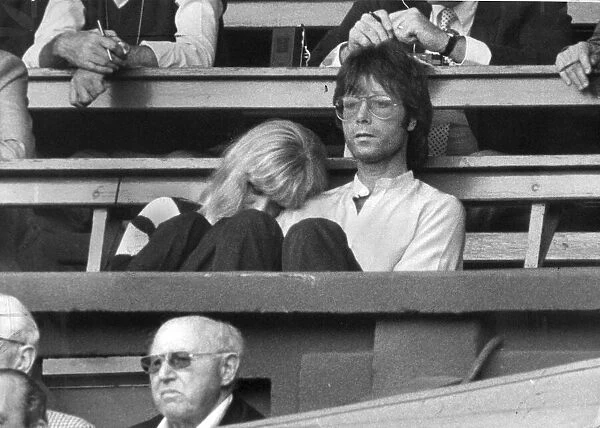 Cliff Richard with Sue Barker leaning on his arm watching Wimbledon tennis - June 1982