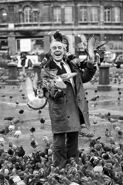 Comedian Max Wall poses in trafalgar Square, London, with seagulls flying on to his head