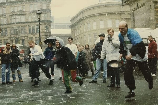 Competitors strugging through snow and sleet to take part in the Shrove Tuesday Pancake