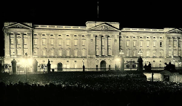 Crowds gather outside the gates of Buckingham Palace following the coronation of George