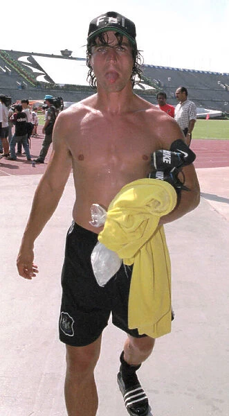 David Ginola pokes his tongue out after finishing a training session in Singapore