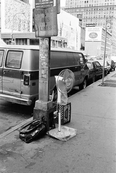 Electric free standing fan, abandoned on street pavement, under sign, Domenico Bus Lines